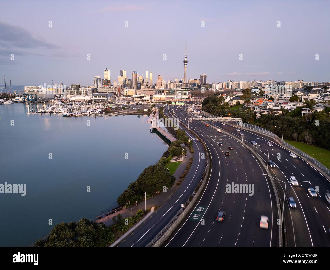 Auckland, New Zealand: Dramatic aerial view of the Westhaven highway leading to Auckland downtown district skyline at sunset in New Zealand. Stock Photo