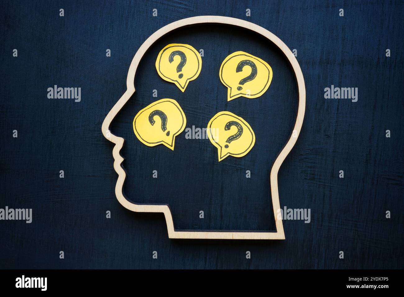 Head with question marks inside symbolizing uncertainty or curiosity. Stock Photo