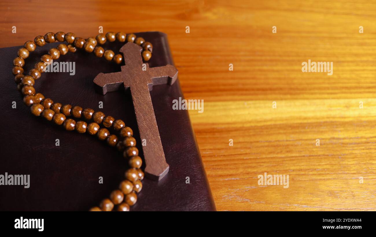 Dark brown wooden cross on a dark brown book symbolizing the spread of ...