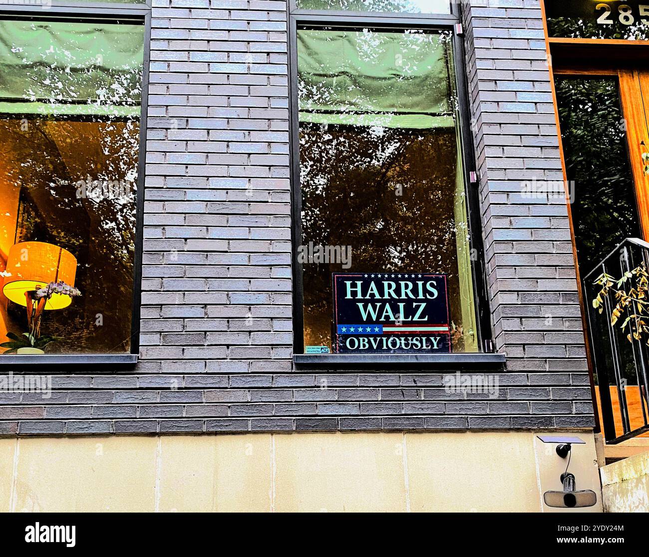 'Harris Walz Obviously' sign in an apartment building window in Cobble Hill, Brooklyn, N.Y., and a lit lamp, September 27, 2024. - Smartphone Captured Stock Image 'Harris Walz Obviously' sign in an apartment building window in Cobble Hill, Brooklyn, N.Y., and a lit lamp, September 27, 2024. - Smartphone Captured Stock Image