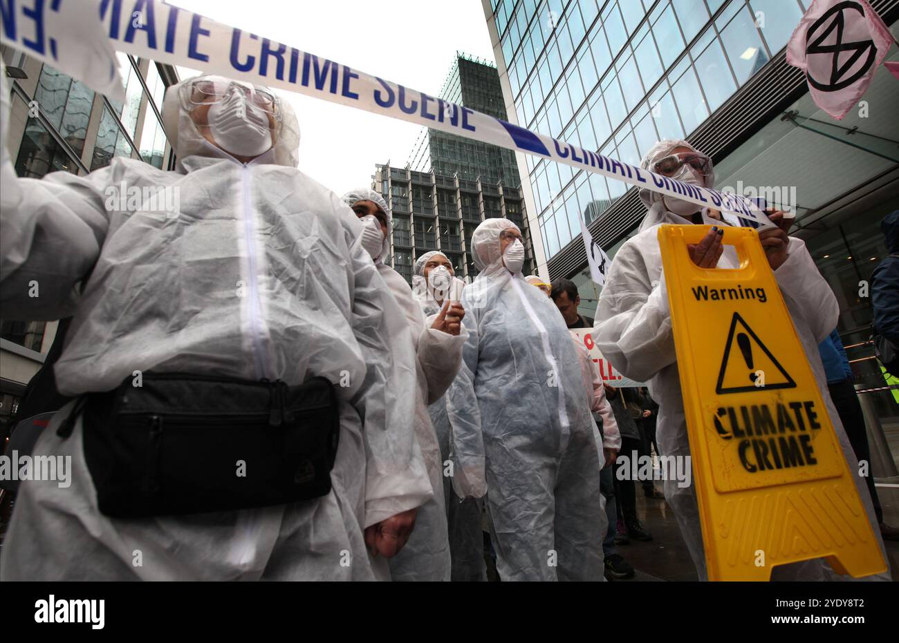 London, England, UK. 28th Oct, 2024. Protesters in Hazmat suits, masks and with crime scene tape protest outside the Walkie-Talkie building home to Tokio Marine insurance company. Extinction Rebellion (XR) walk around the City of London and stop and demonstrate outside the offices of insurance companies that are continuing to insure fossil fuel companies despite the warnings of a climate crisis from scientists. The protesters believe if the insurance companies stopped their involvement with these companies they would struggle to continue to mine. The action is the first of a week long protes Stock Photo