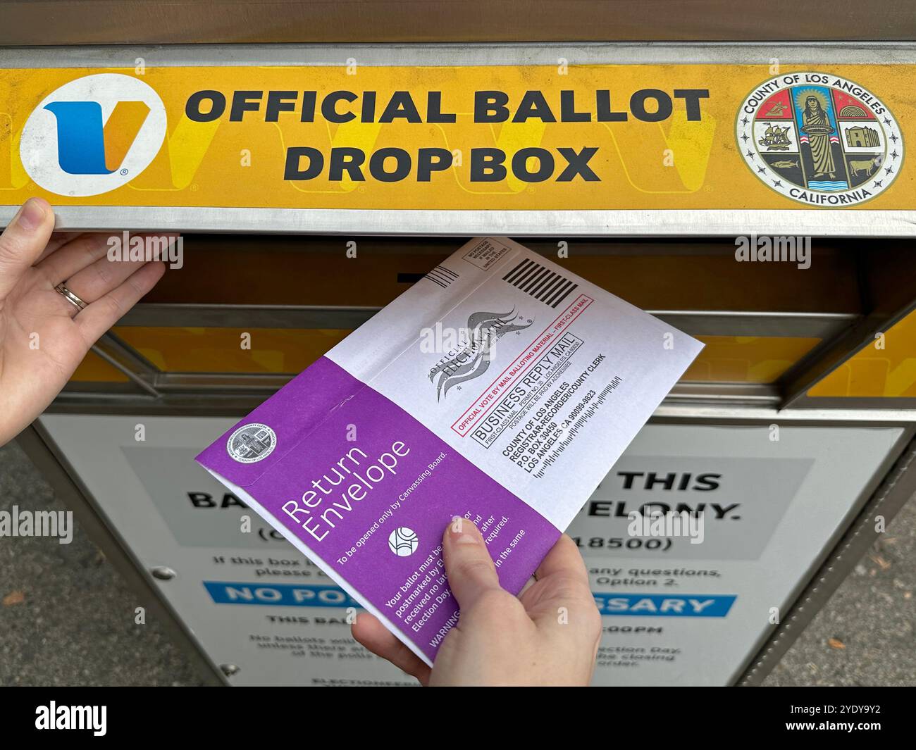 Burbank, California / USA - Oct. 27, 2024: A mail-in ballot for the 2024 presidential election is dropped off by hand at an official ballot drop box. - Smartphone Captured Stock Image