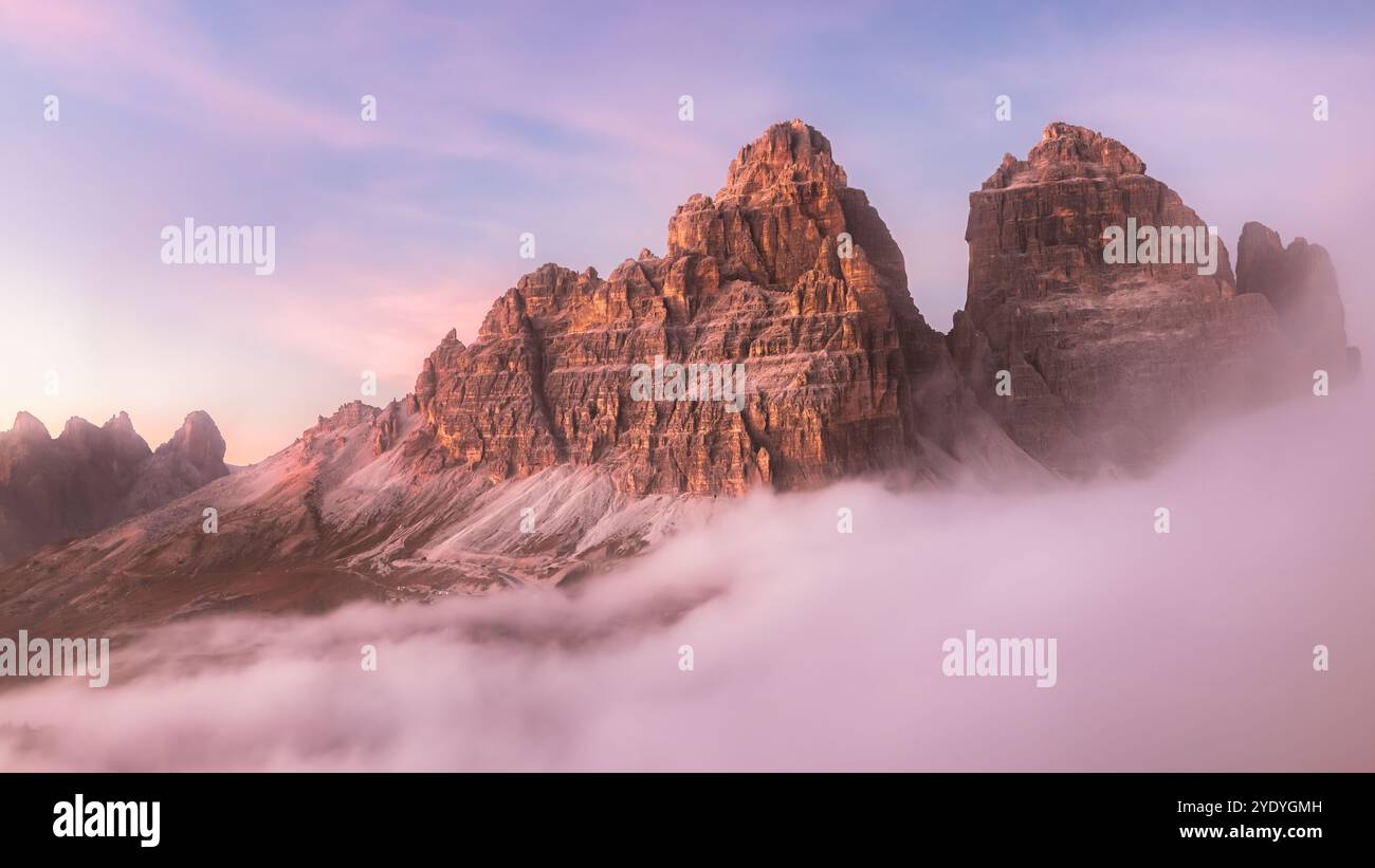 Dramatic view of Tre Cime di Lavaredo emerging through a cloud ...