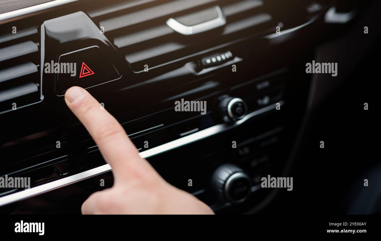 Man pressing red triangle car hazard light button Stock Photo