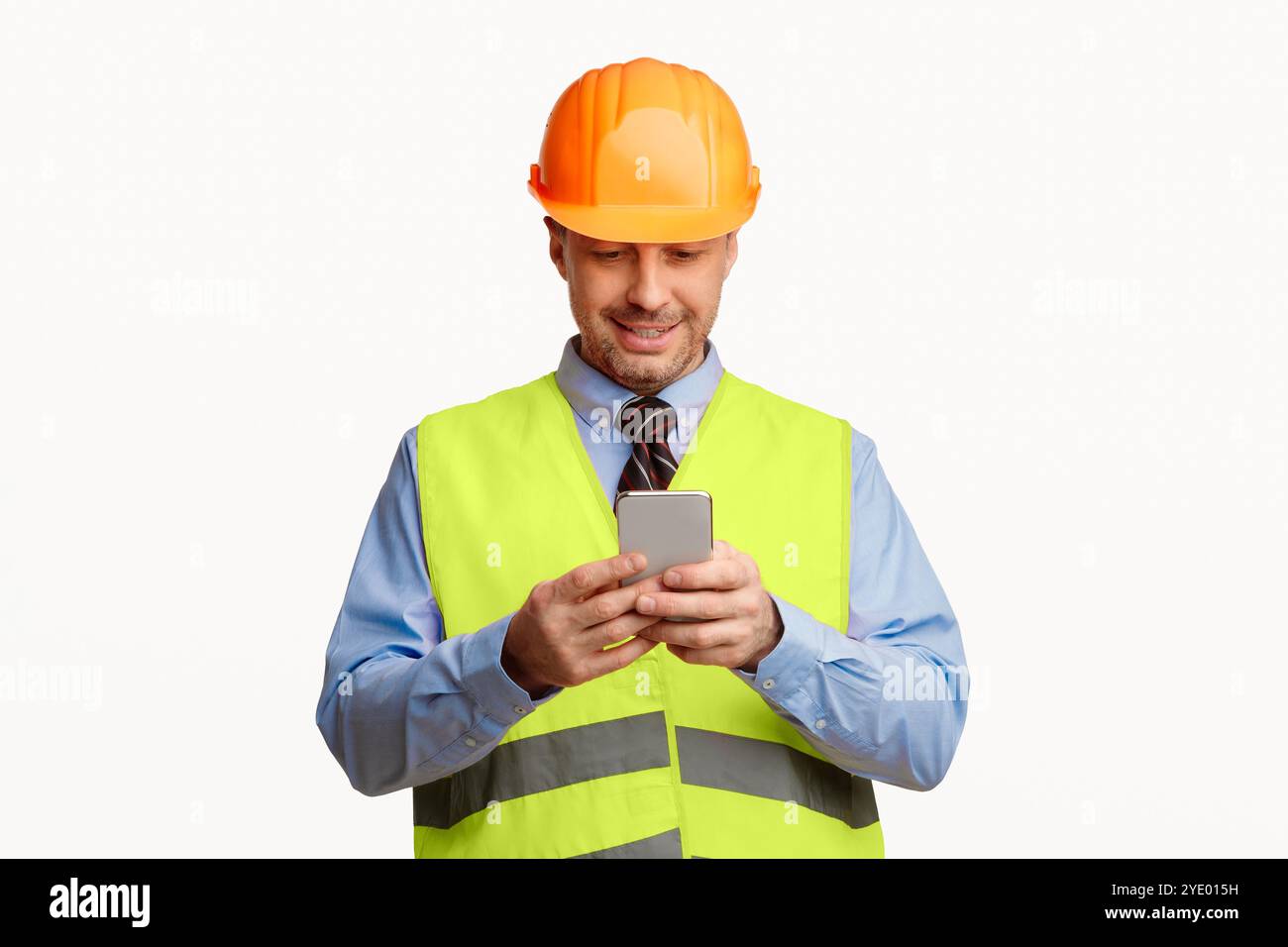 Construction Worker Using Smartphone Standing On White Studio Background Stock Photo