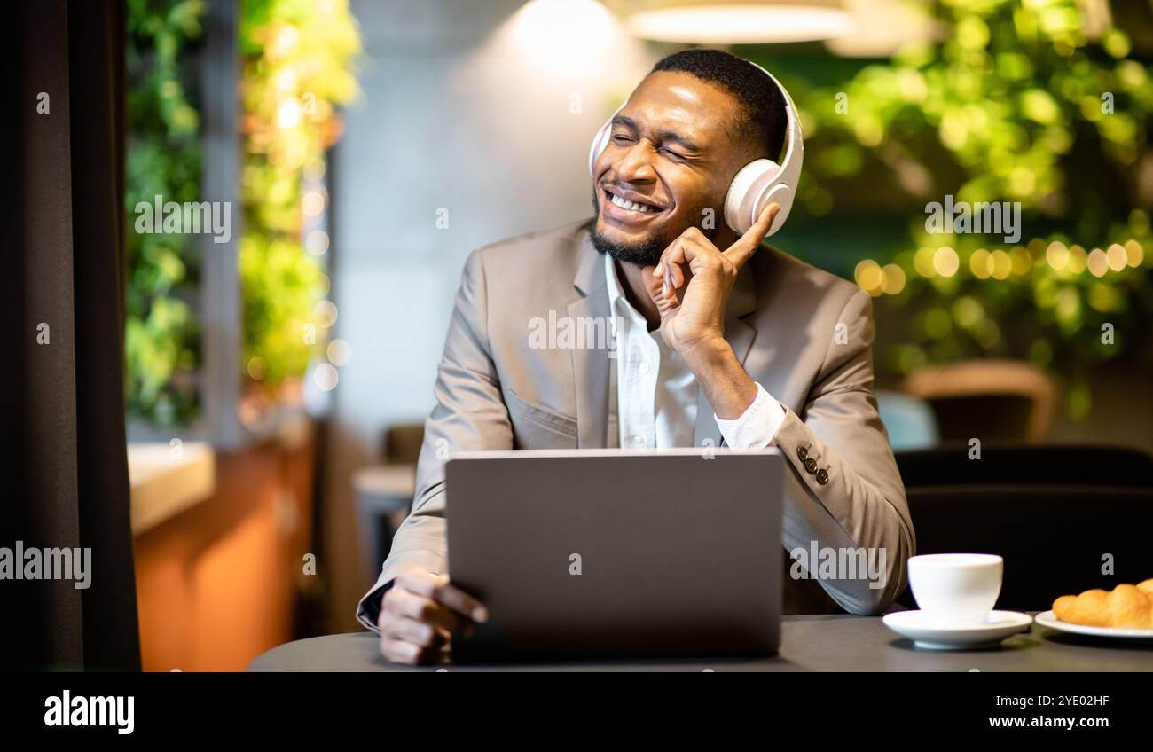 Young black businessman listening to music with headset Stock Photo