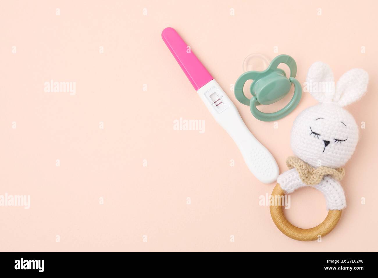 Pregnancy test, rattle and pacifier on beige background, top view ...
