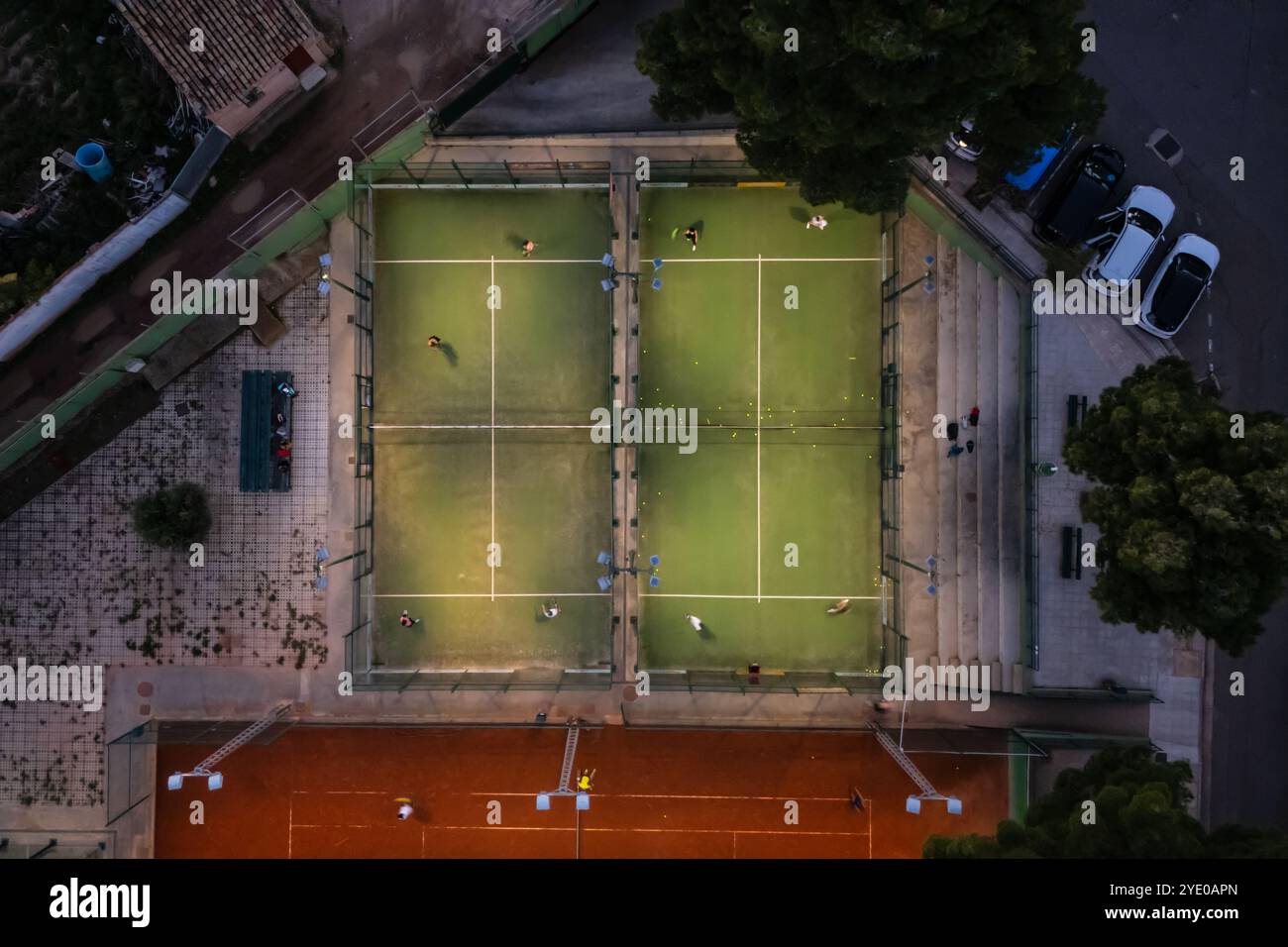 Aerial vertical view of people playing paddle tennis in an illuminated ...