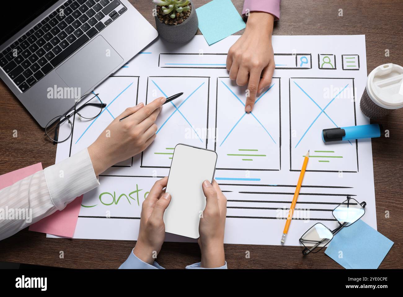 Developing UI design. Designers creating website wireframe on paper at wooden table, top view Stock Photo