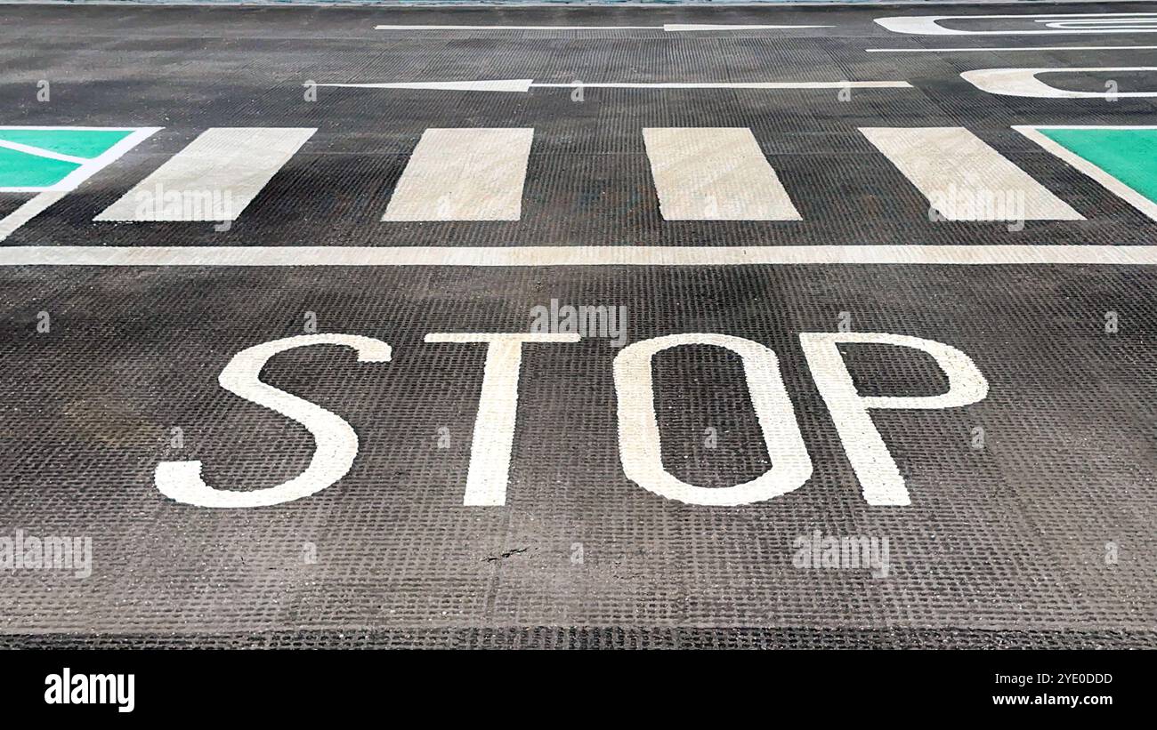 Stop sign and pedestrian crossing on the floor of a car park. No people. - Smartphone Captured Stock Image