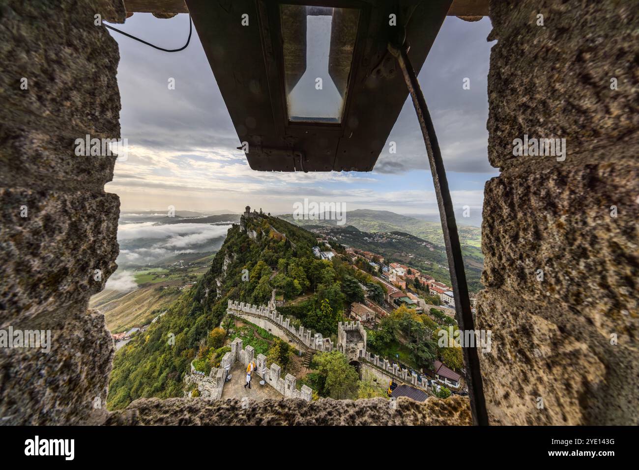 View from a hatch in the first tower La Guaita to the second tower La Cesta, San Marino. The three towers of San Marino are also known as the three feathers, illustrated by the shape of the weather vanes. Salita Alla Cesta, Passo delle Streghe, City of San Marino, San Marino Stock Photo