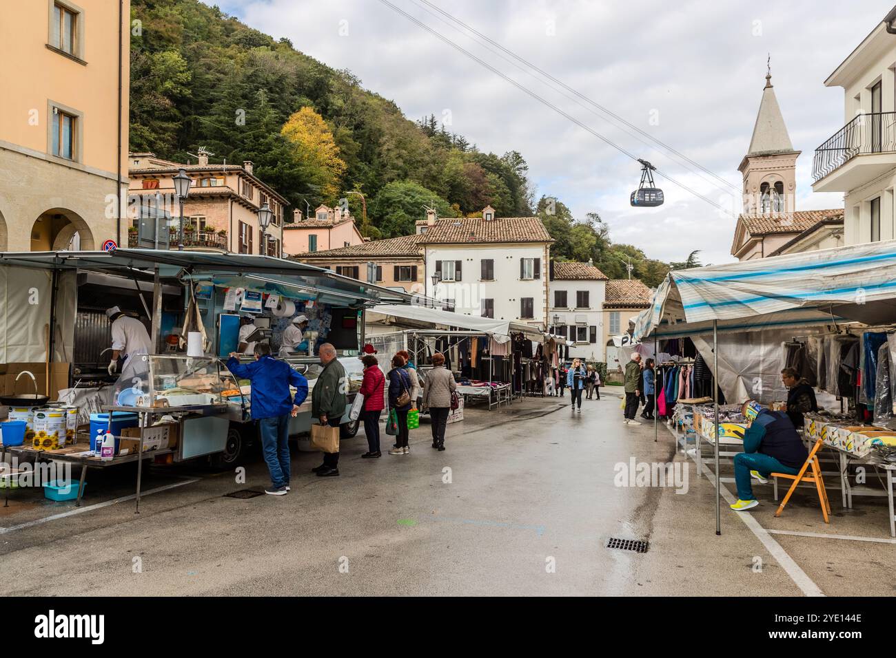 A cable car climbs 338 meters between the center of San Marino and the village of Borgo Maggiore in just a few minutes and offers breathtaking views of the Adriatic coast, tiled roofs and farmland. Cable car over the market of Borgo Maggiore. Piazza di Sopra, Borgo Maggiore, San Marino Stock Photo