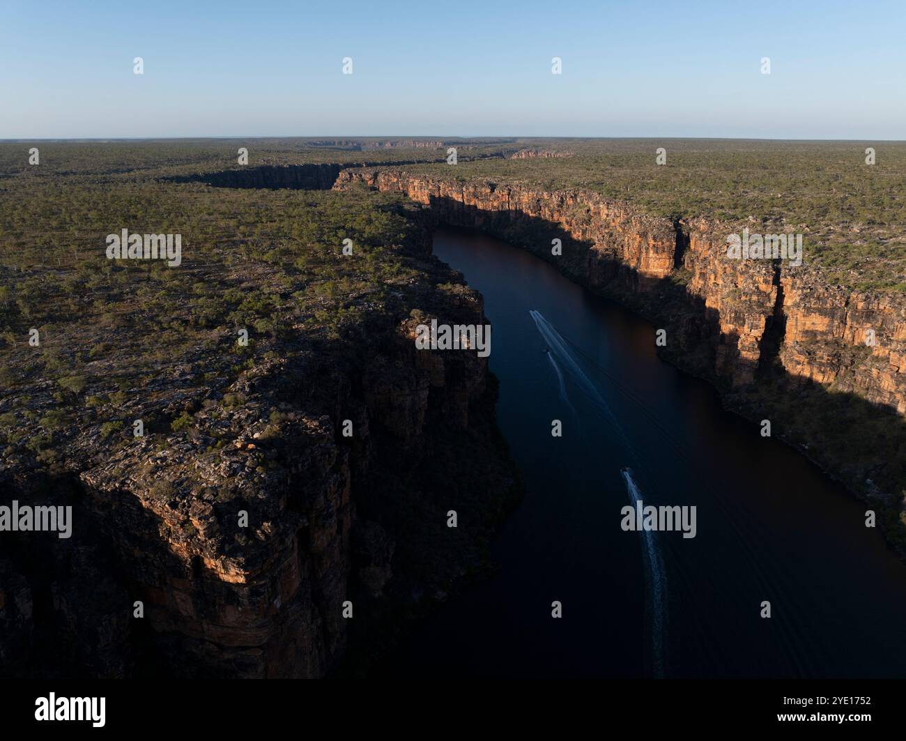 Aerial view of small boats travelling in King George River in The Kimberley, Western Australia during sunset Stock Photo