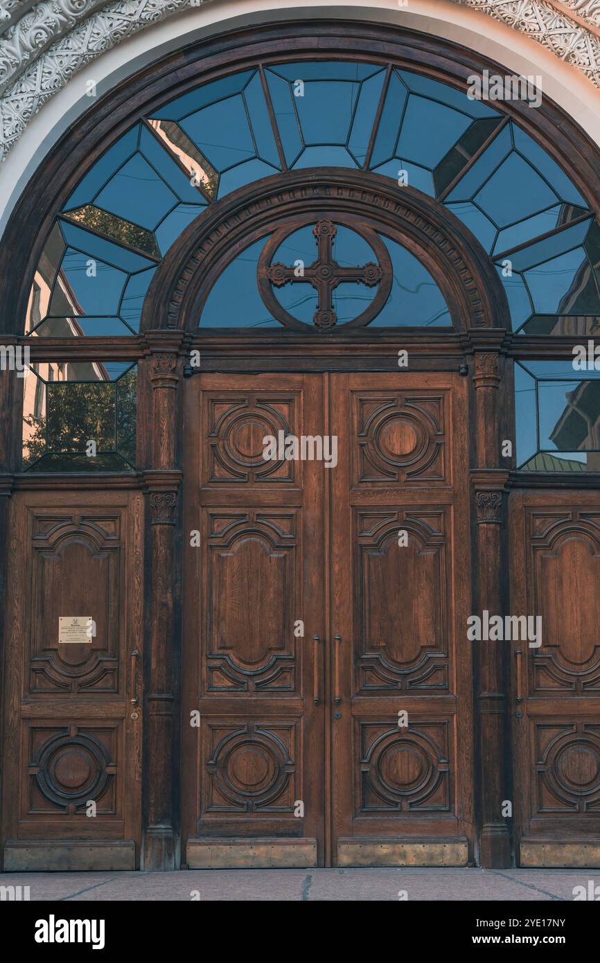 Ornate wooden door with arched window and decorative carvings Stock ...