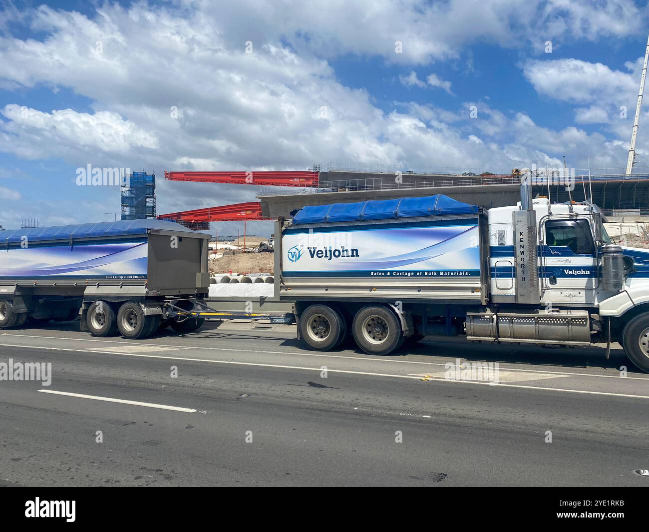 Dual trailer truck passes construction of the M12 motorway in Western Sydney,New South Wales,Australia - Smartphone Captured Stock Image