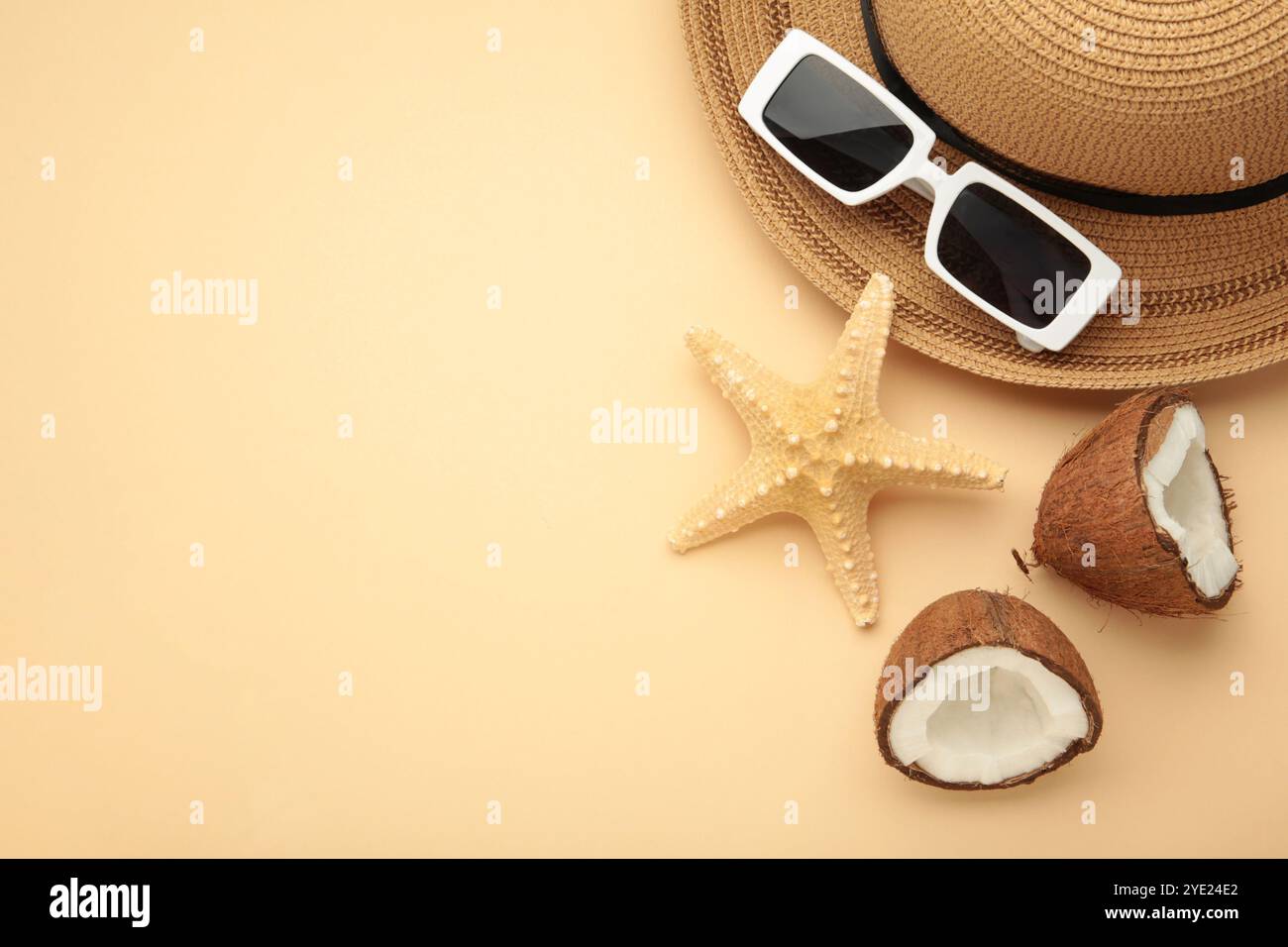 Summer accessories with coconuts on beige background. Space for text Stock Photo