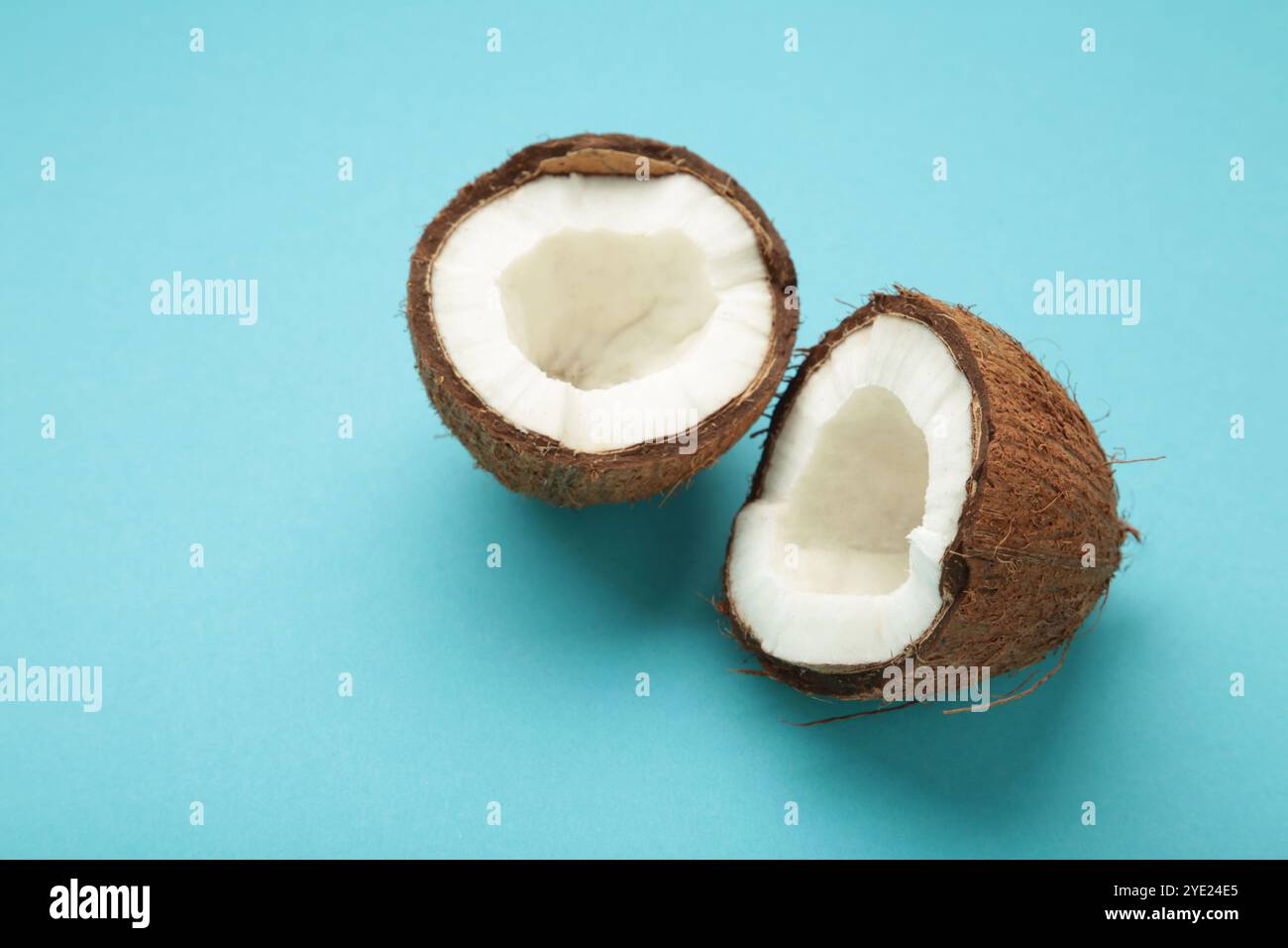 Coconut with half on blue background. Space for text. Top view Stock Photo