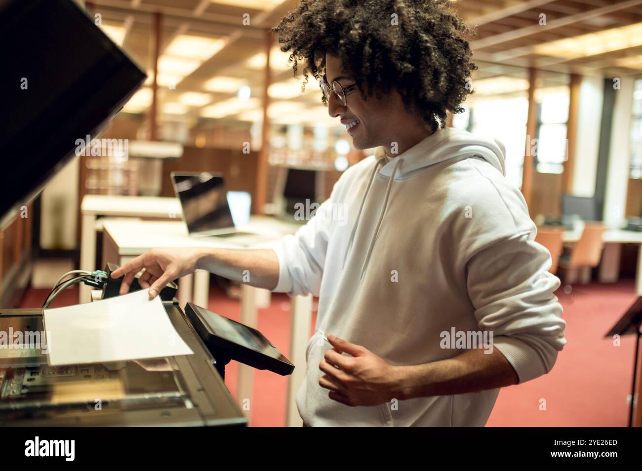 Young man making copies on xerox in the library Stock Photo - Alamy