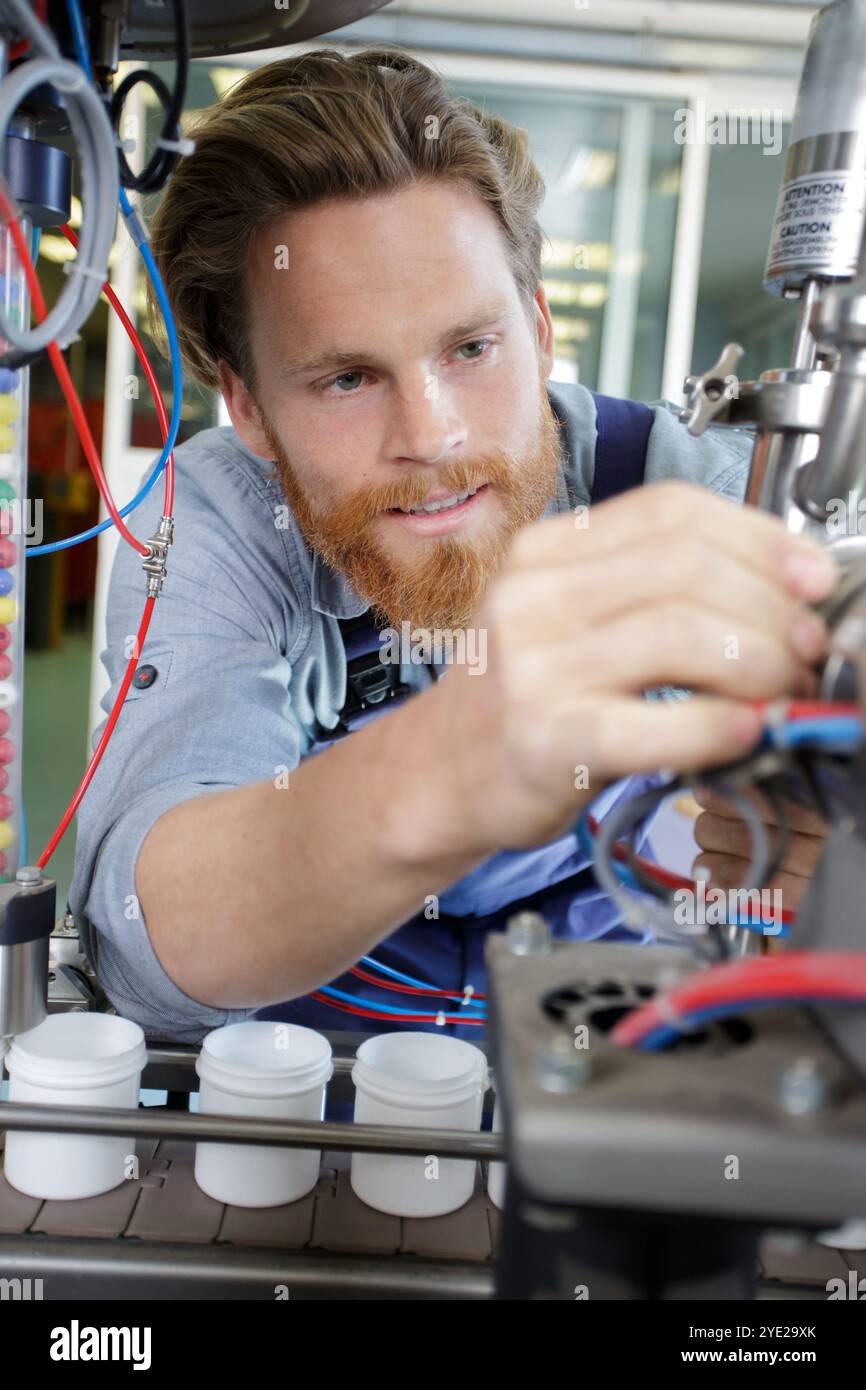man assembles electronic components on a machine Stock Photo