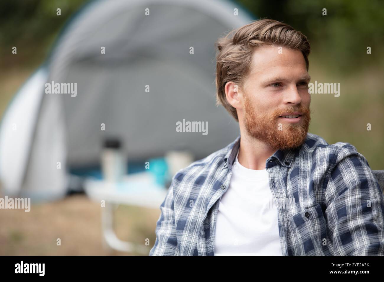 handsome cheerful man camping outdoors Stock Photo
