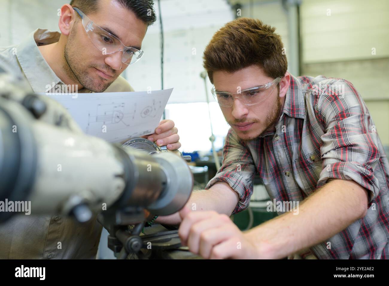 engineers setting up machinery from detailed plans Stock Photo