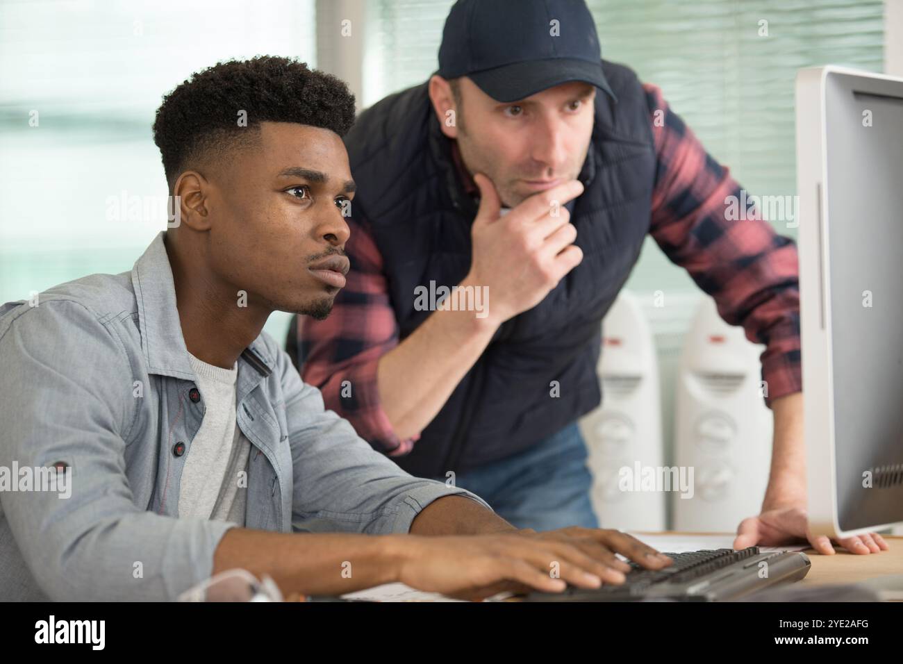 two serious men looking at computer screen Stock Photo
