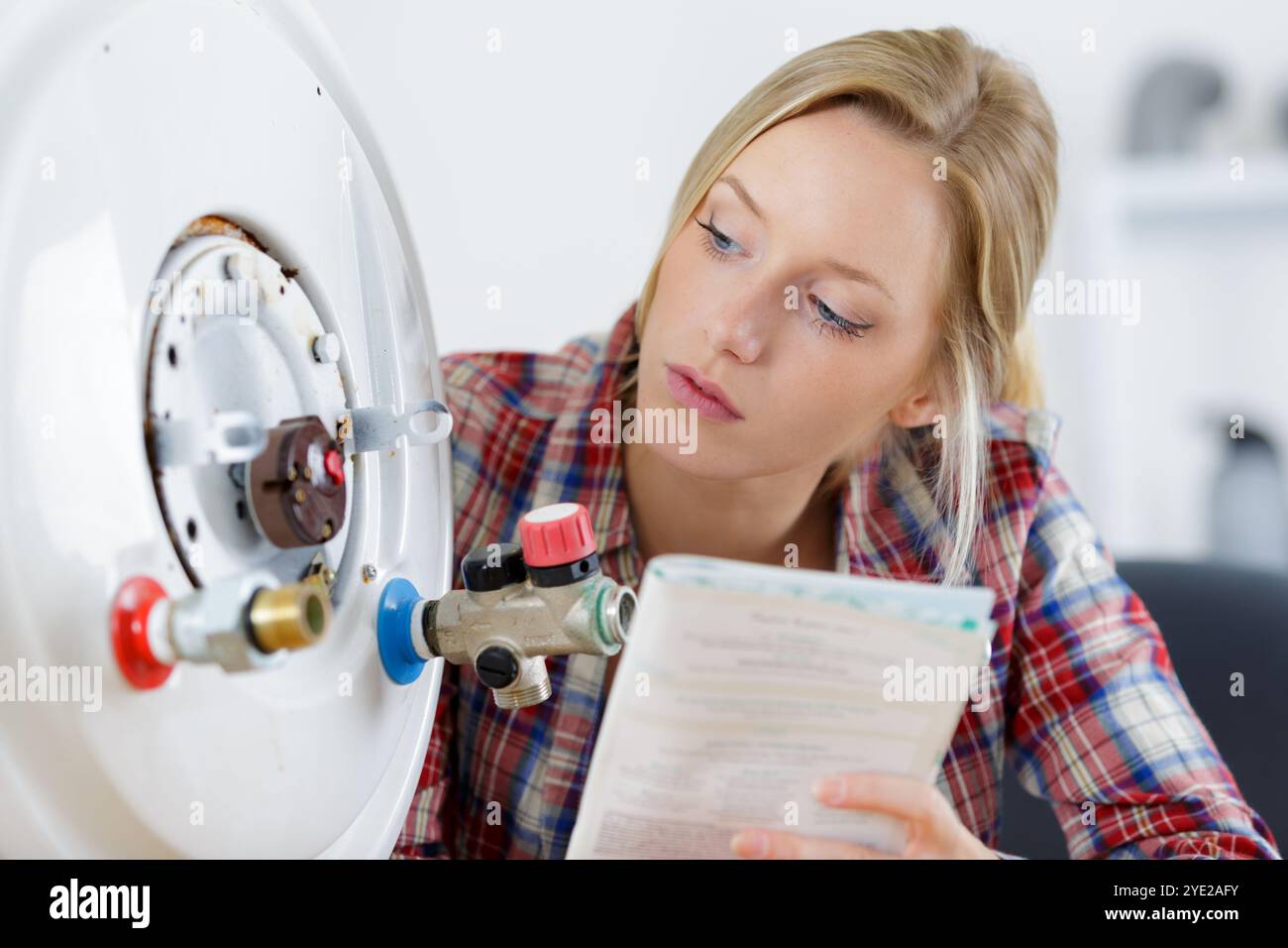 female trainee plumber working on central heating boiler Stock Photo