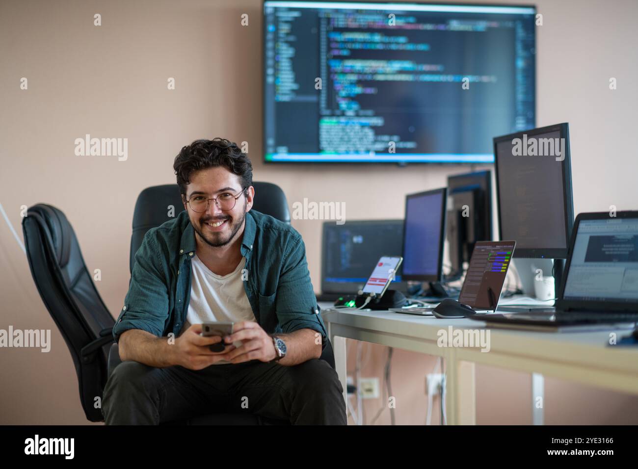 Smartphone Programmer A programmer diligently testing smartphone applications Stock Photo - Alamy