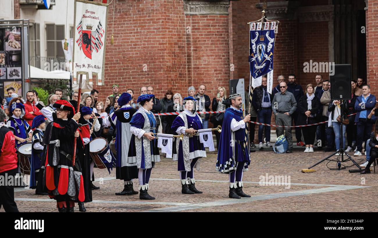 A vibrant group of performers dressed in traditional costumes plays ...