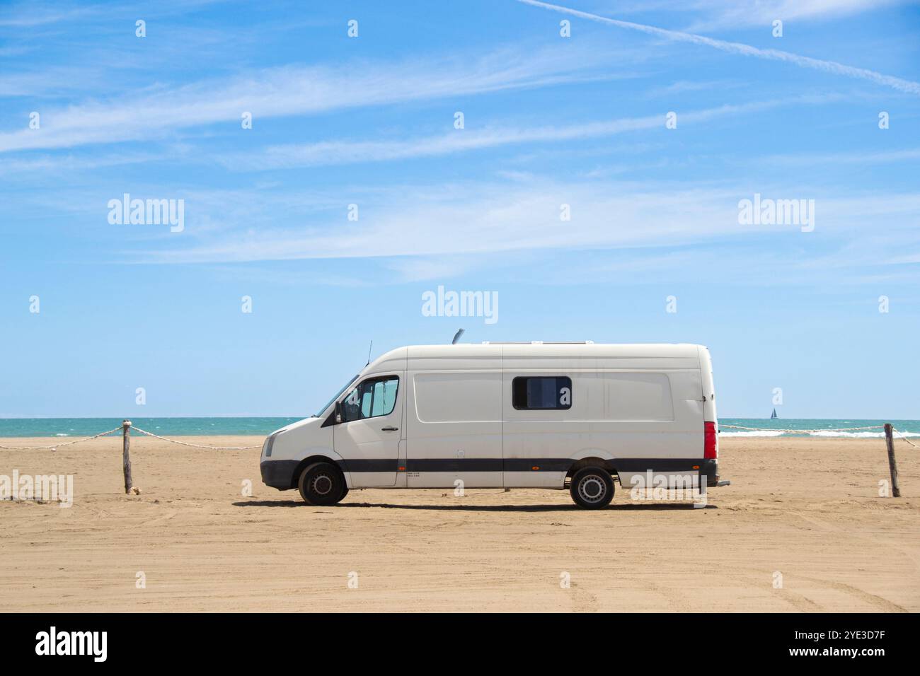 Old white camper van parked on a beach by the sea in the Ebro Delta ...