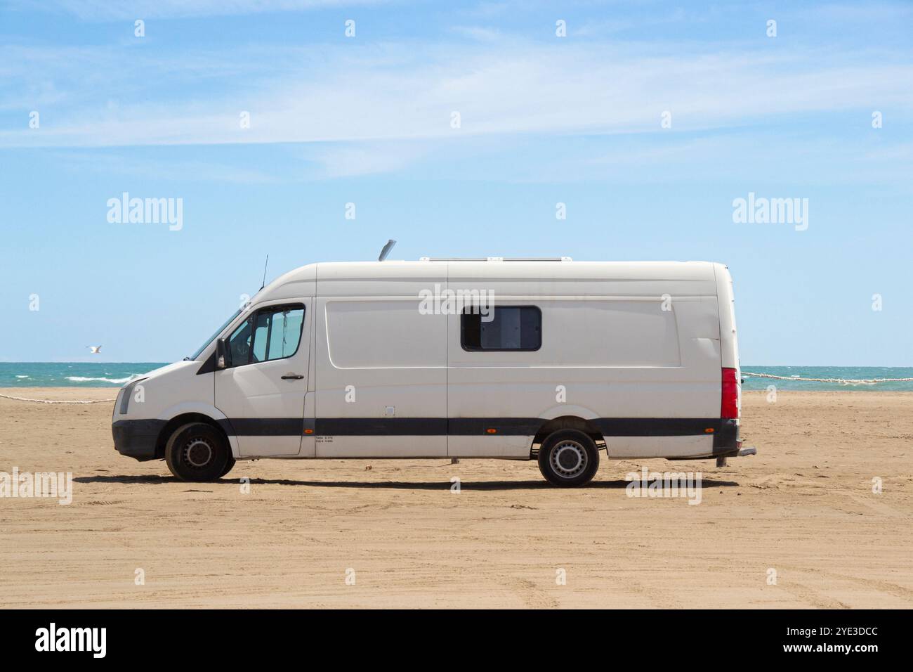 Old white camper van parked on a beach by the sea in the Ebro Delta ...