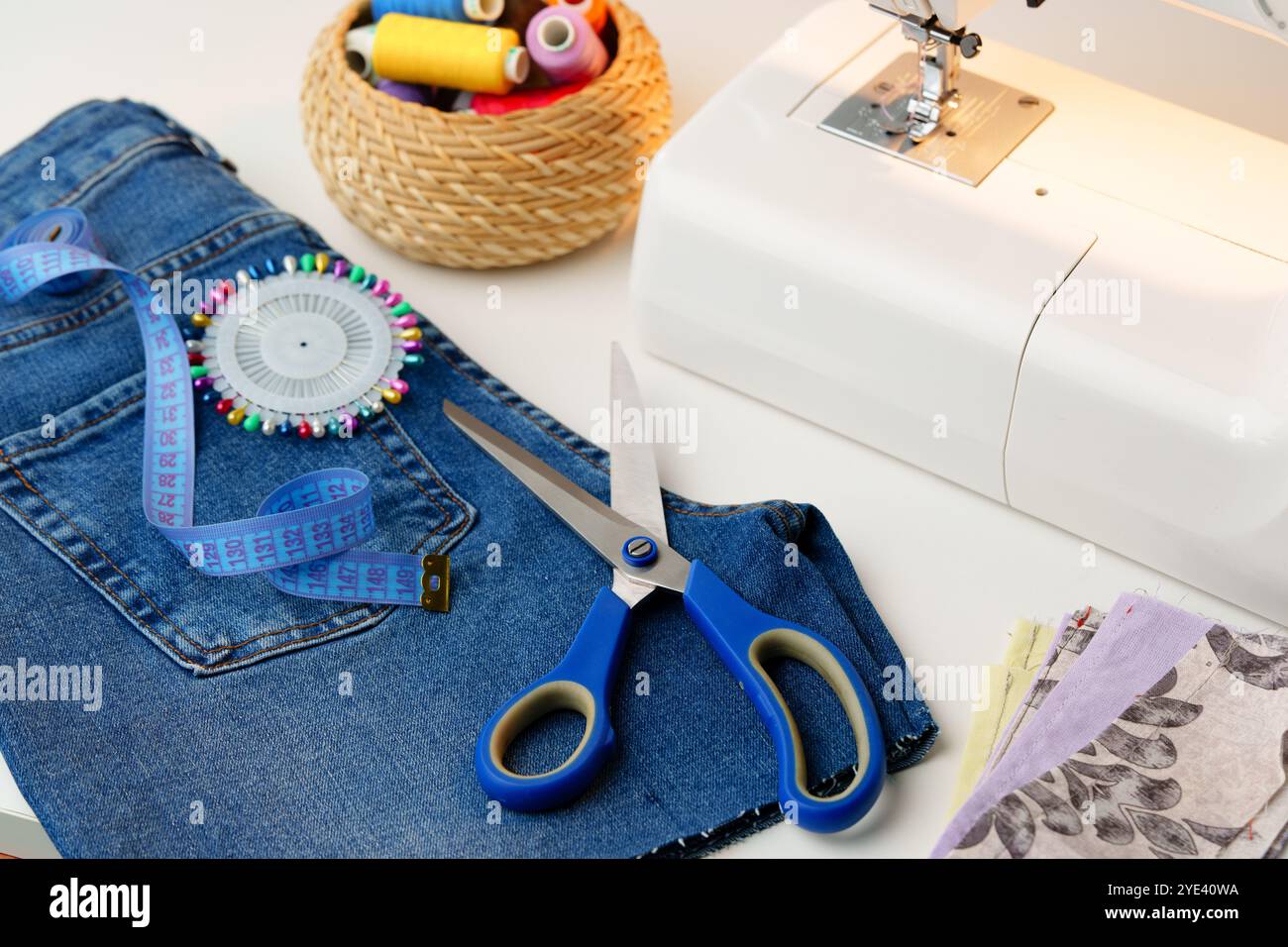 A sewing setup featuring a sewing machine, colorful threads, and denim ...