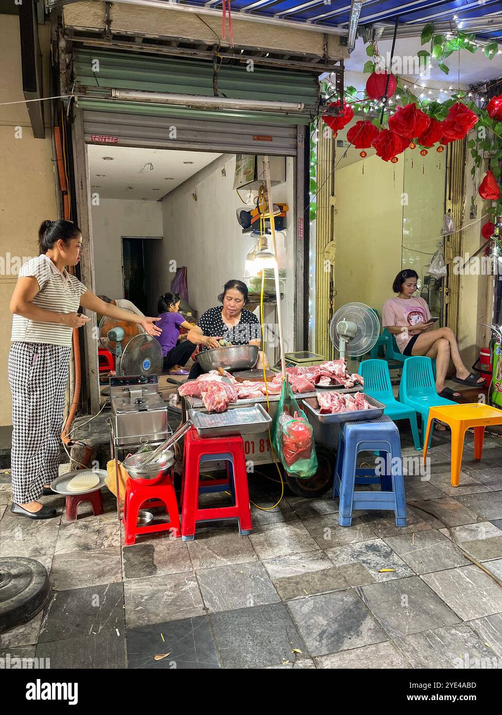 Hanoi, Vietnam: Hanoi, Vietnam: Vietnamese women selling meat on a stall at Dong Xuan Market, built by the French administration in 1889 in Hoan Kie Stock Photo
