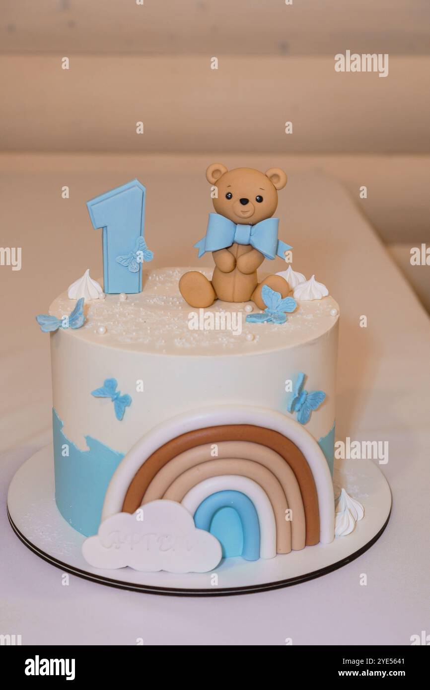 Adorable One-Year-Old Birthday Cake Featuring a Bear and Rainbow Decorations. Stock Photo