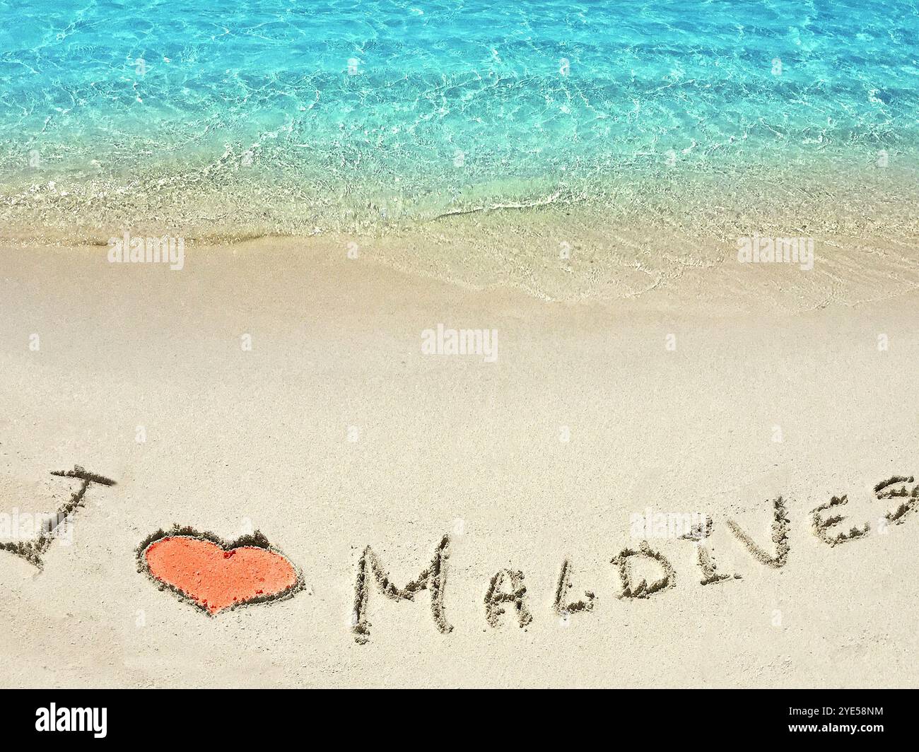 Inscription "I LOVE MALDIVES" in the sand on a tropical island ...