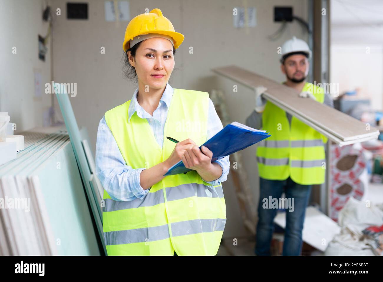 Smiling female civil engineer with documents at construction site Stock Photo
