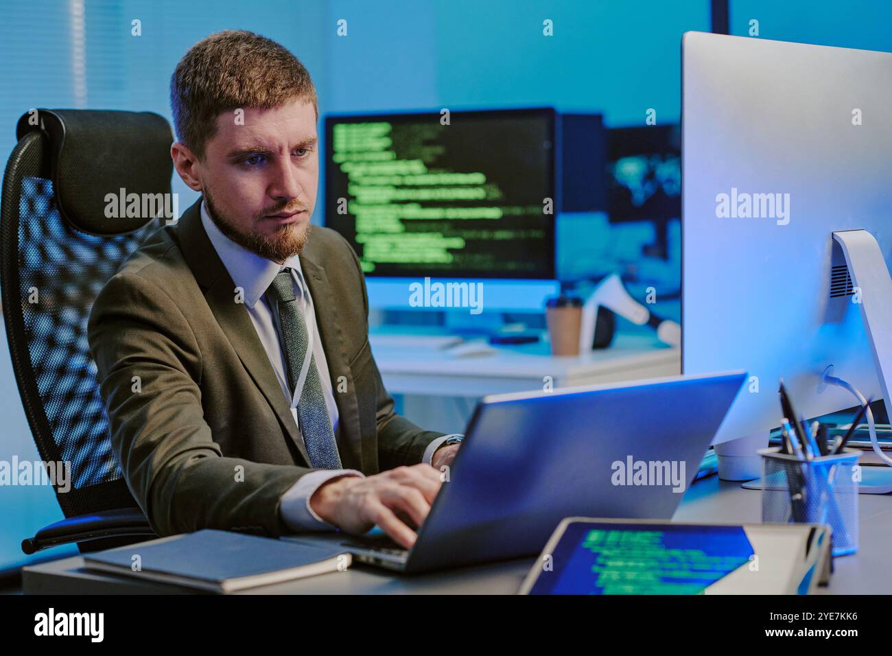 Young Man Working On Laptop In Data Security Office Stock Photo