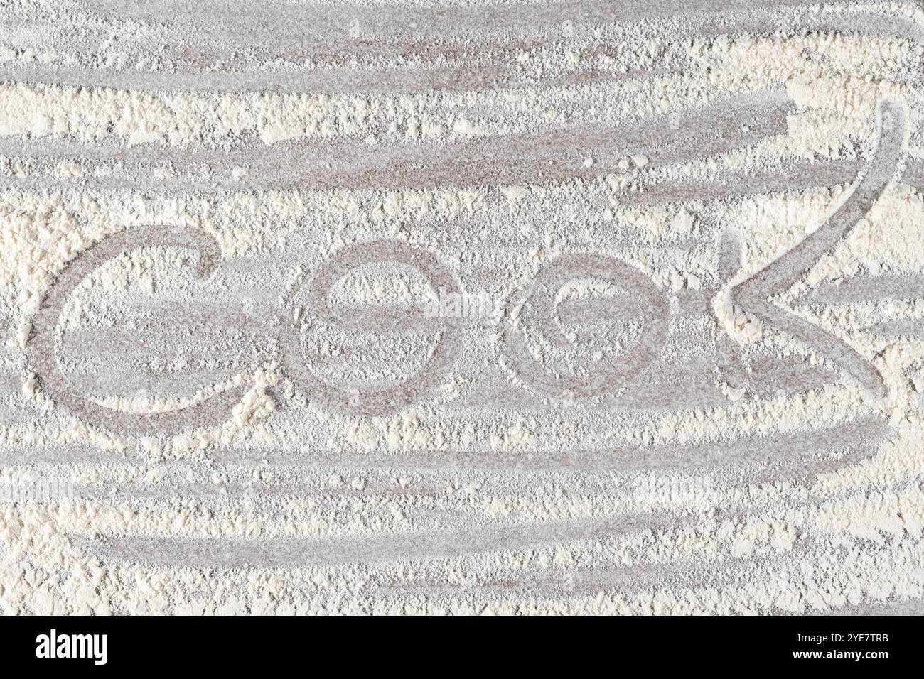 Grey cooking background of spilled wheat flour on stone background with text cook Stock Photo