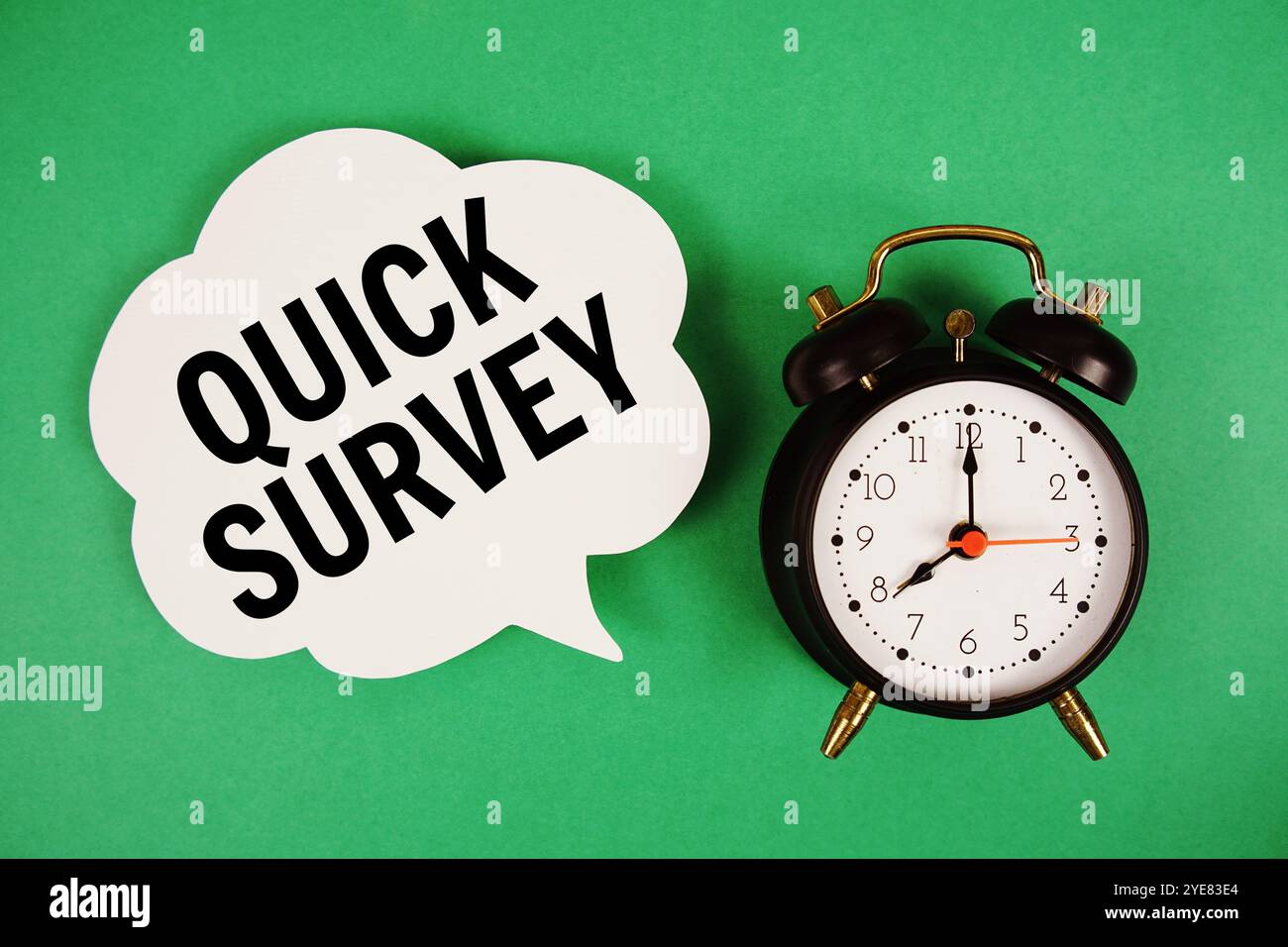 Quick Survey text on speech bubble with alarm clock on green background Stock Photo