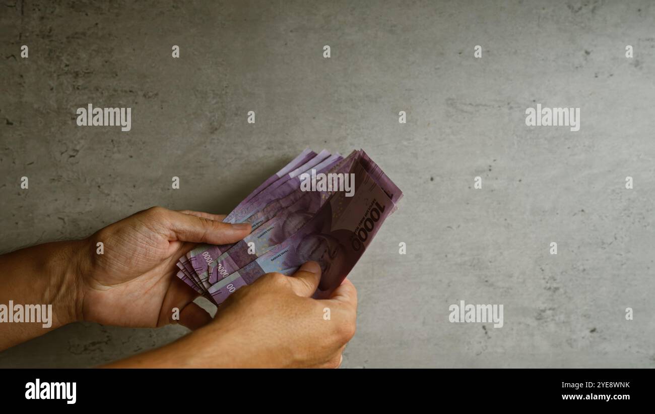 Hands counting indonesian rupiah money hi-res stock photography and ...