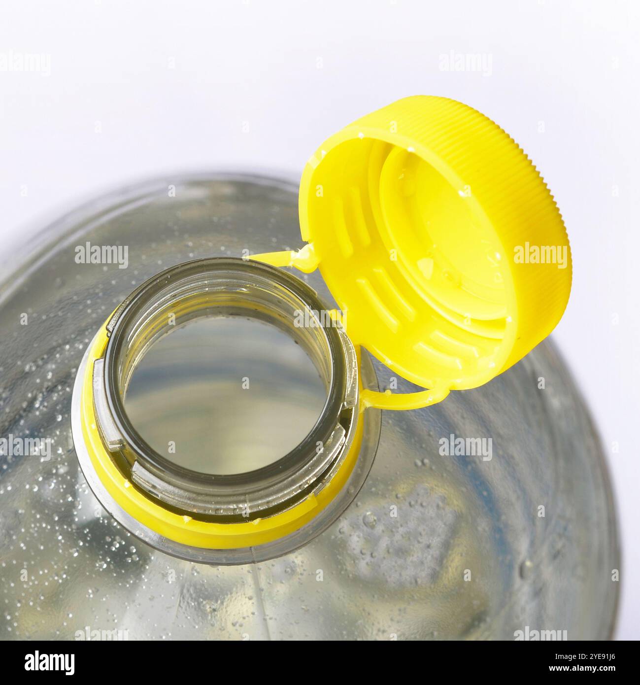 New style of attached Plastic bottle cap top designed so that the top cannot be separated from the bottle to help recycling. This directive aims to re Stock Photo
