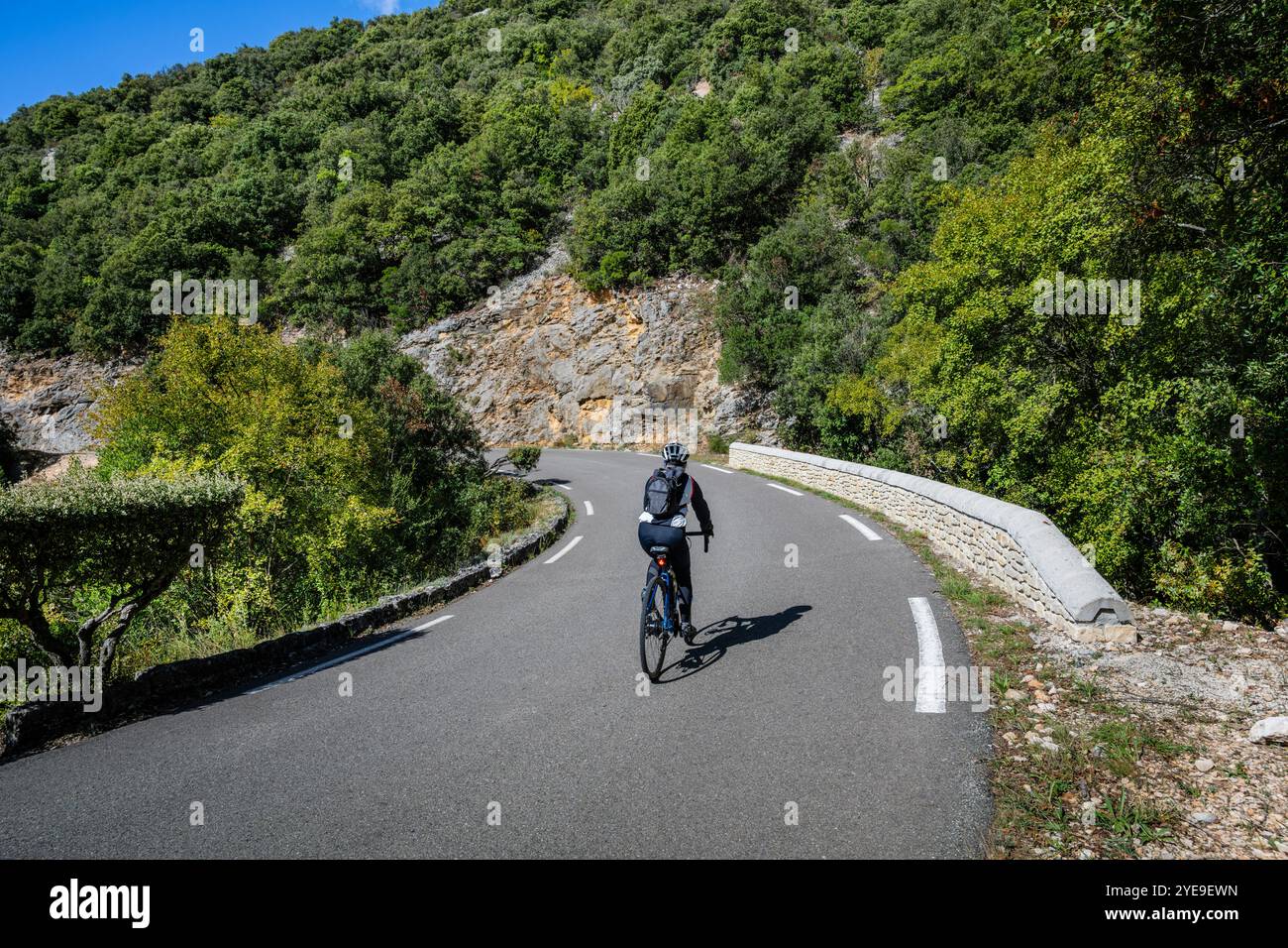Mature female cyclist descending Gorges de la Nesque, Provence, France. Stock Photo