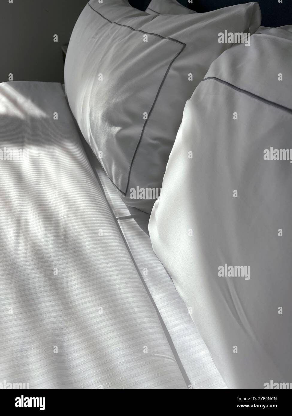 Bed with white sheets and pillows at a hotel - Smartphone Captured Stock Image