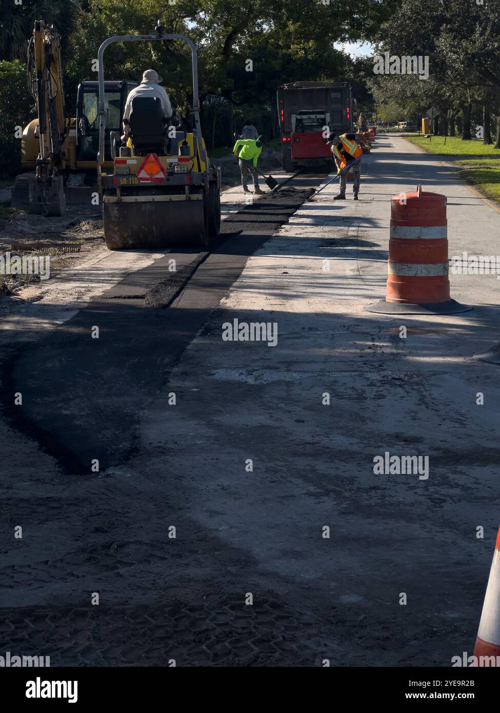 Ashpalt Paving Machine and workers doing street reparation, Plantation, Florida, USA - Smartphone Captured Stock Image