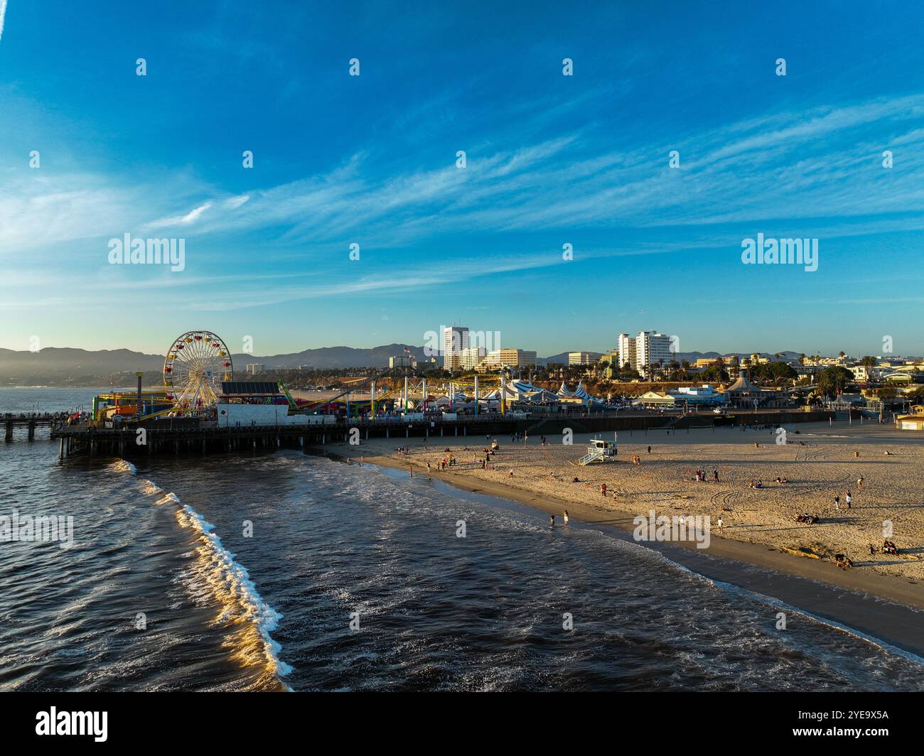 The Santa Monica Beach Pier in California, with Pacific Park at Sunset ...
