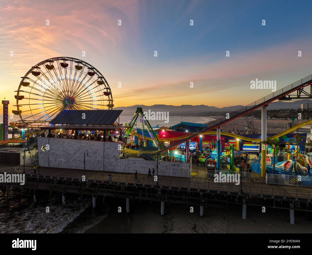The Santa Monica Beach Pier in California, with Pacific Park at Sunset ...