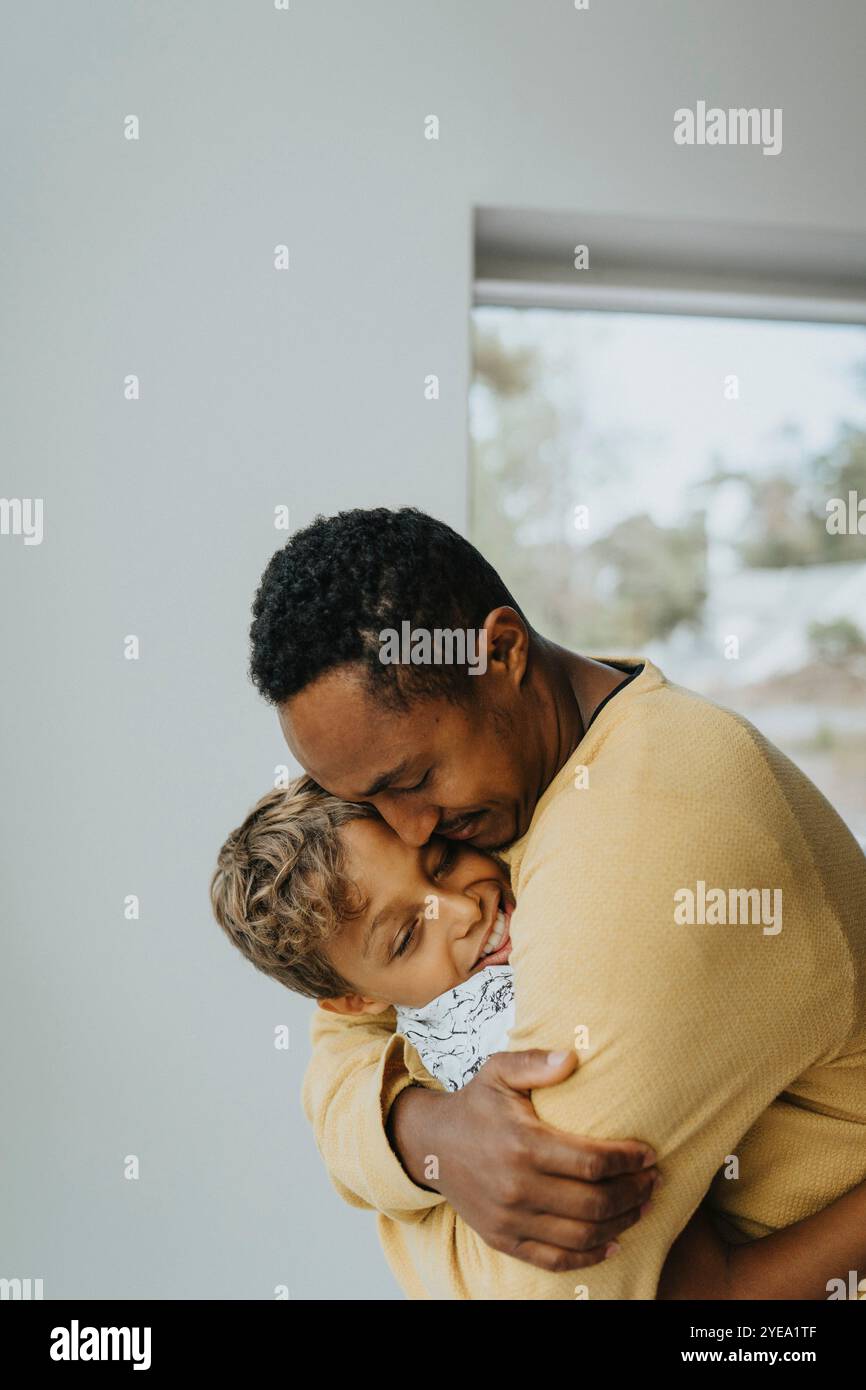 Affectionate father embracing son at home Stock Photo