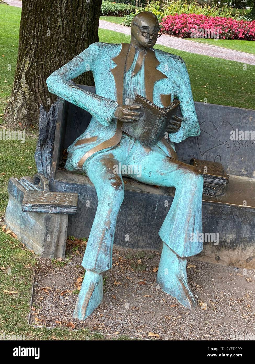 Sculpture of Man Reading on Park Bench - Smartphone Captured Stock Image