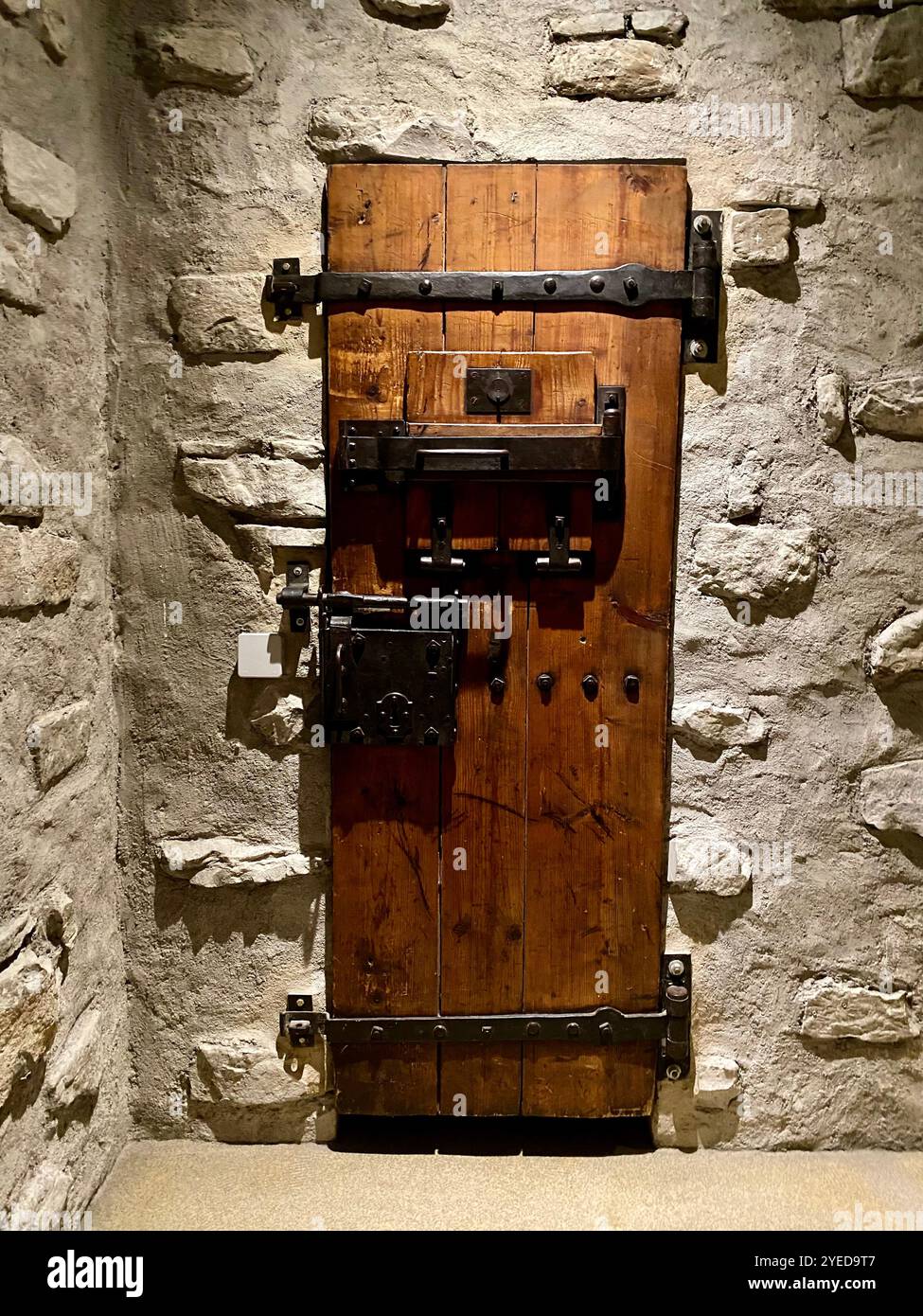 Rustic Wooden Door with Iron Hardware in Stone Wall - Smartphone Captured Stock Image