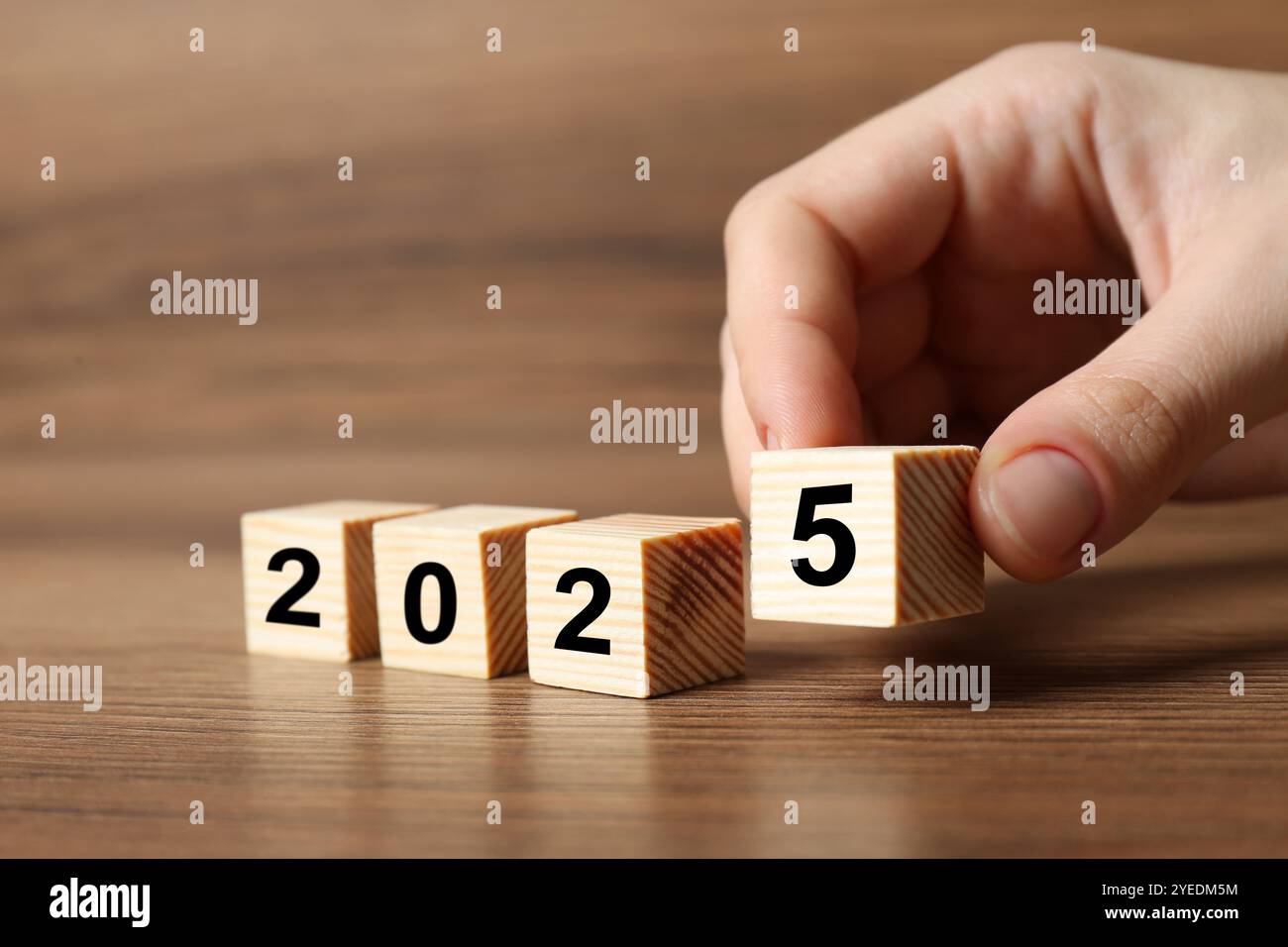 2025 New Year. Woman putting wooden cube with number 5 on table, closeup Stock Photo